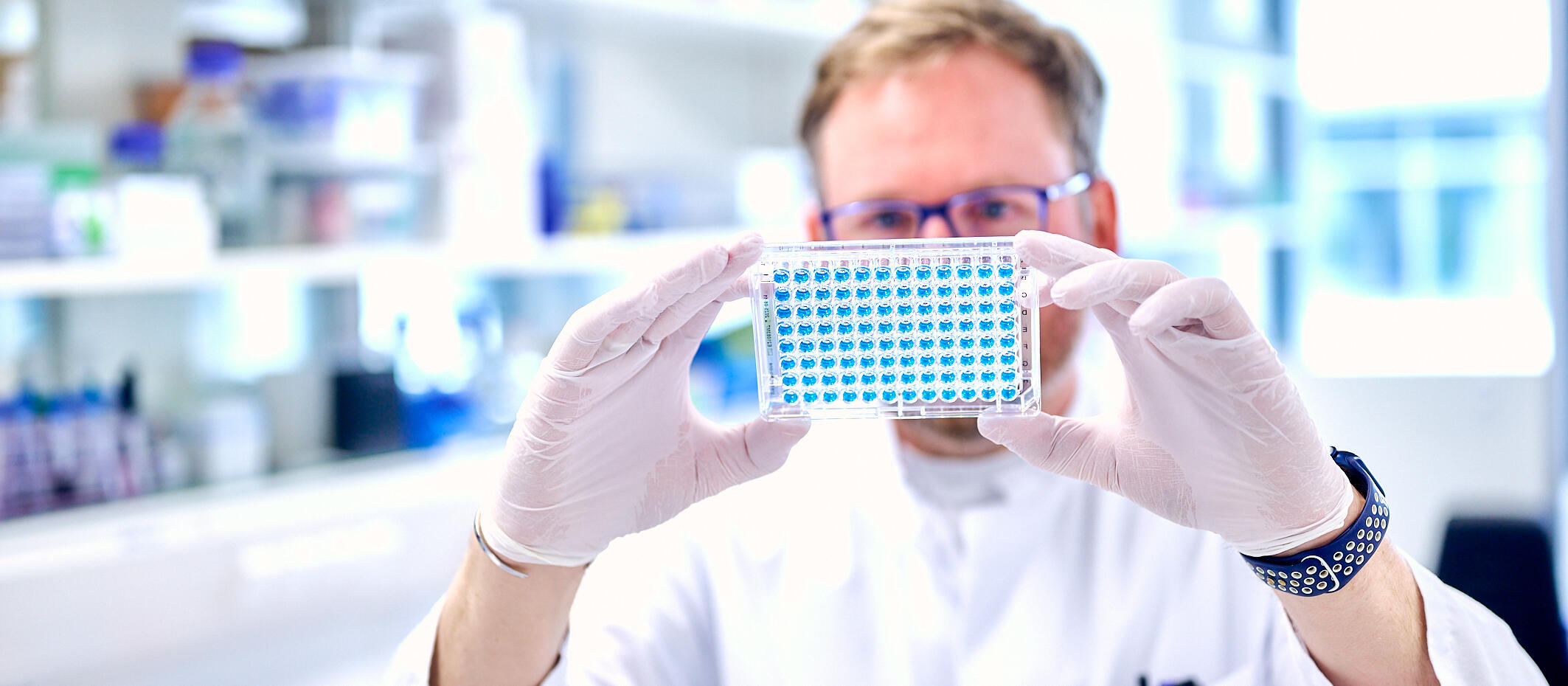 Scientist with multiwell plate