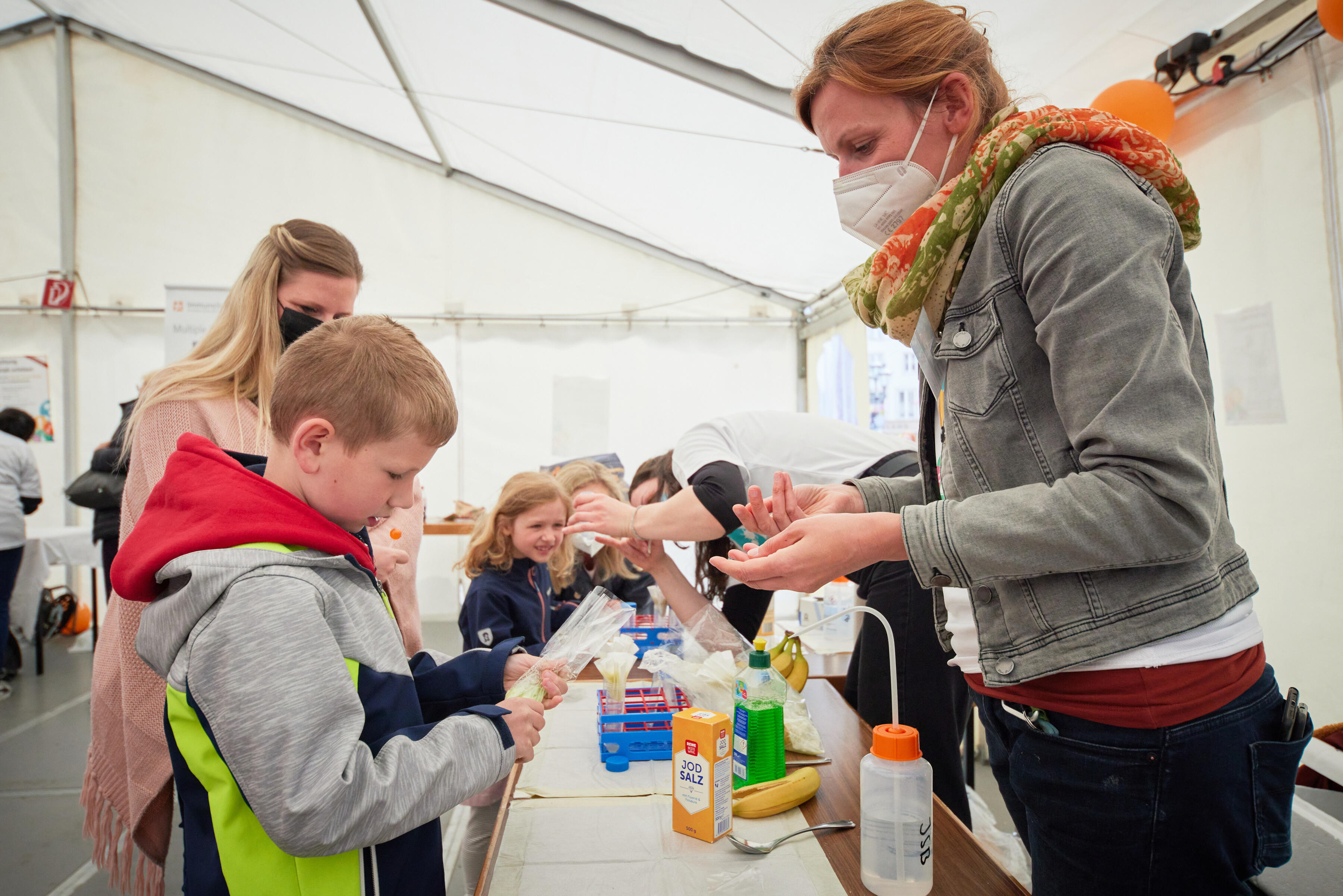 Day of Immunology 2022 - Dr. Alexandra Krämer showing kids how to extract DNA from a banana