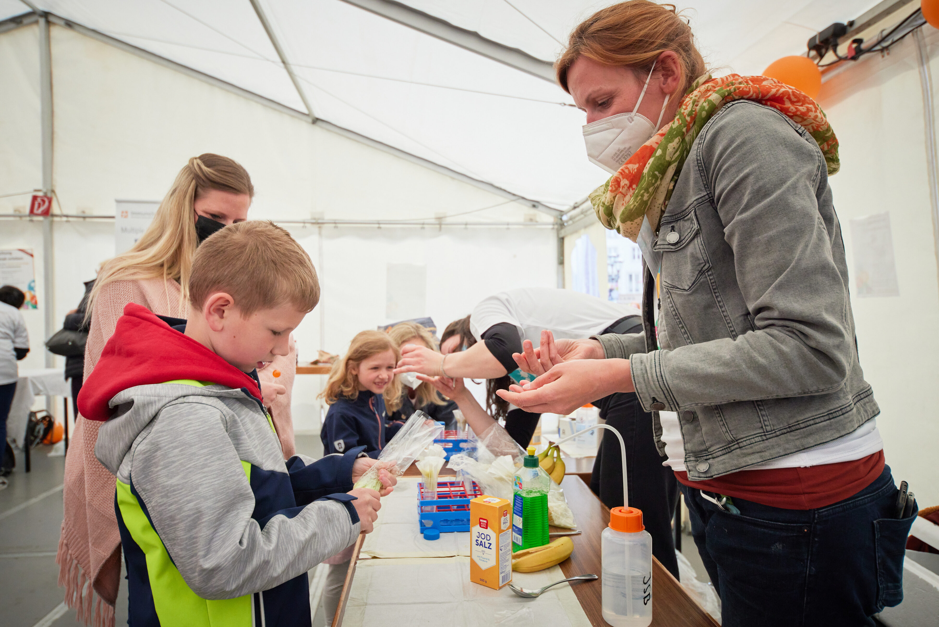 Day of Immunology 2022 - Dr. Alexandra Krämer showing kids how to extract DNA from a banana
